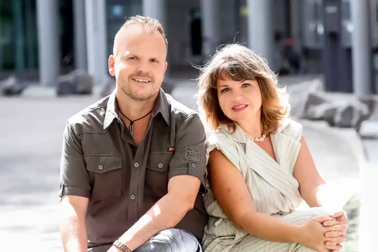 Manuela Lukasczyk und Marco Hörder sitzen nebeneinander und lächeln