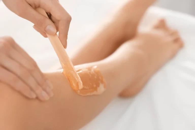 Eine junge Frau erhält gerade eine Waxing Behandlung am Bein